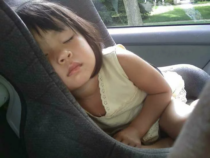 Фотография маленькой девочки, уснувшей в машине