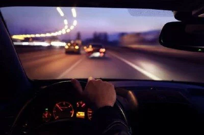 Фотография едущего за рулем человека в темное время суток